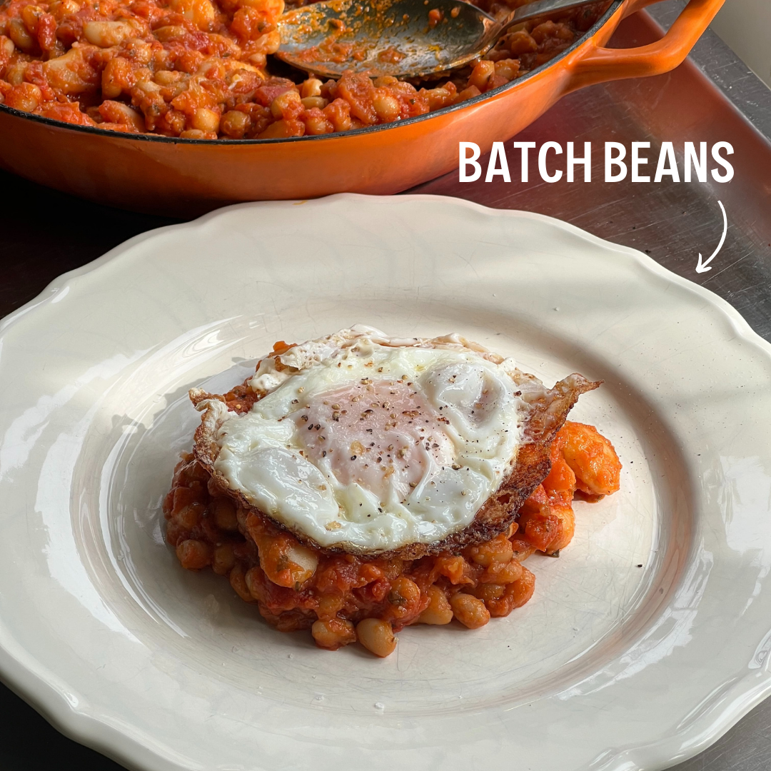 Beans served on a plate with egg and freeze-dried bell pepper pieces