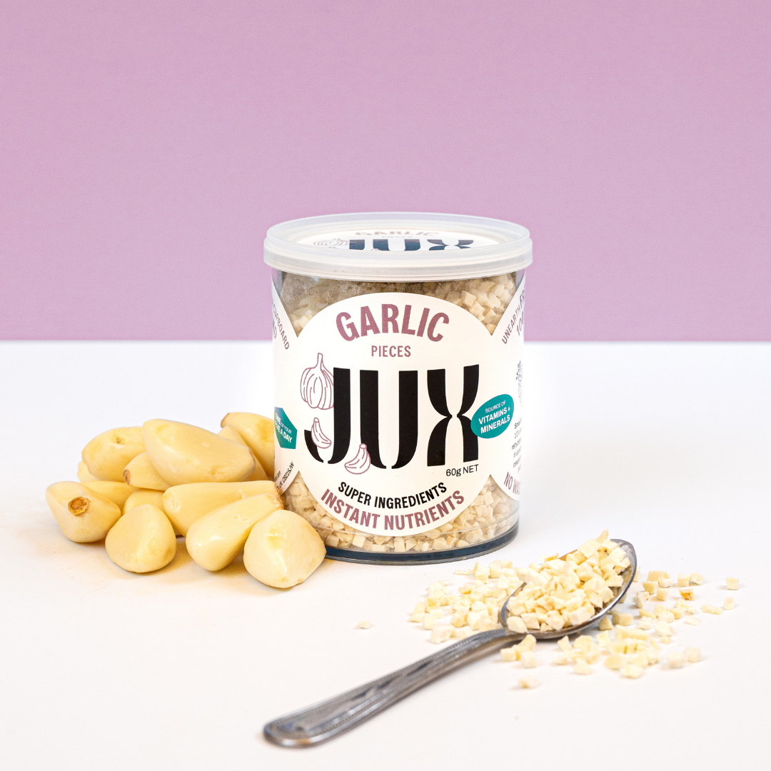 JUX freeze-dried Garlic pieces in jar and on a teaspoon next to fresh garlic