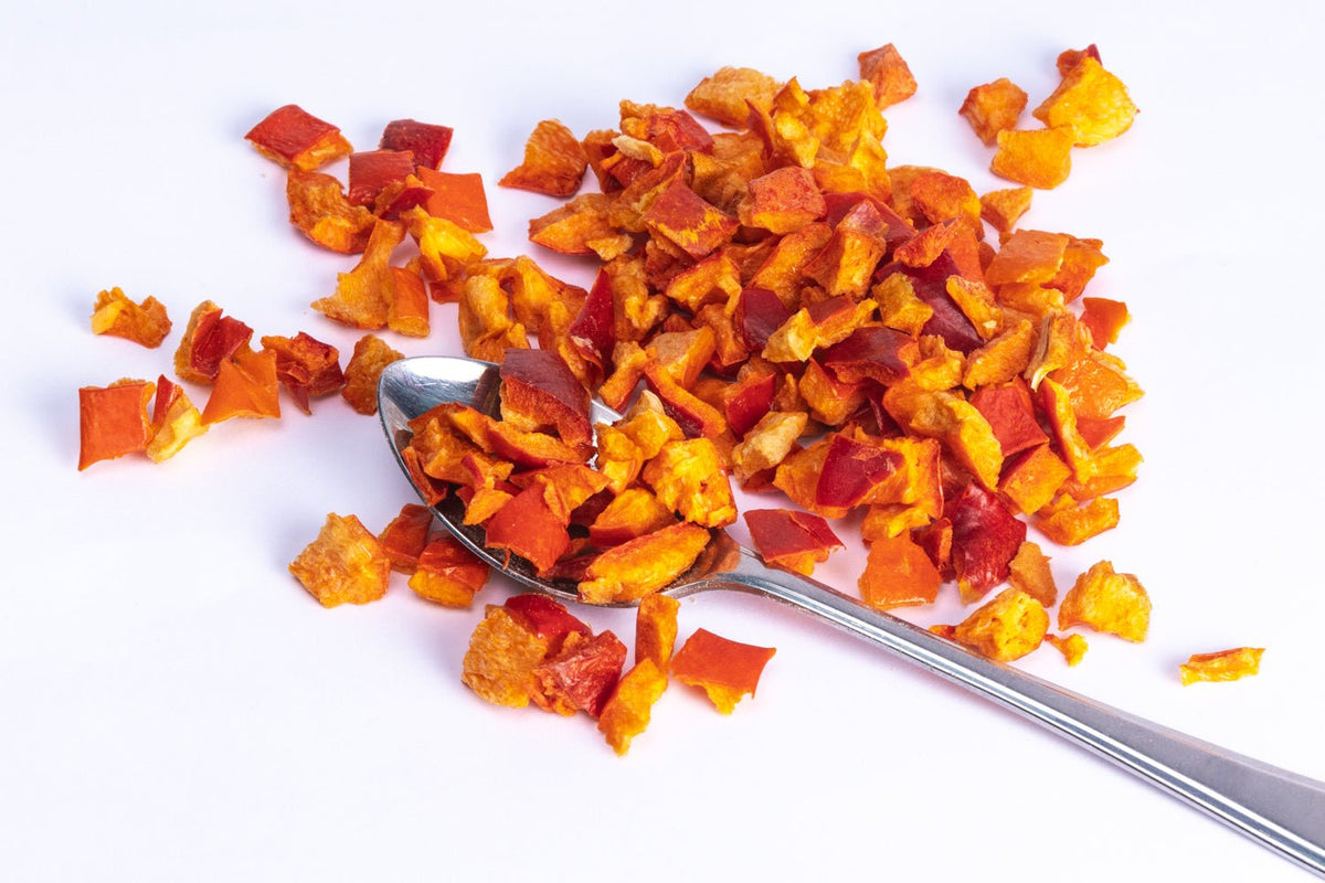 JUX chopped freeze-dried red bell pepper pieces on a teaspoon